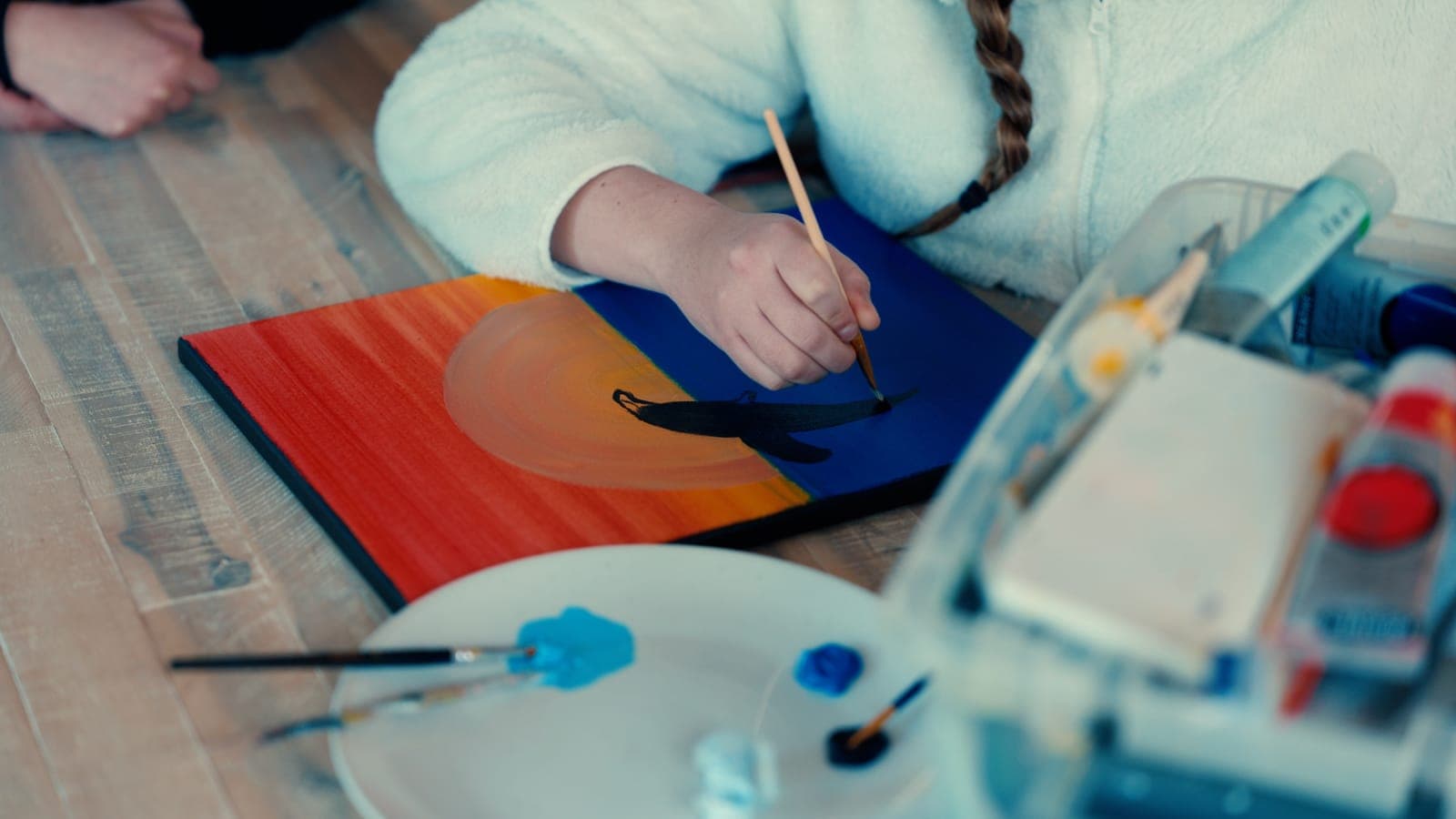 A participant painting a sunset on canvas