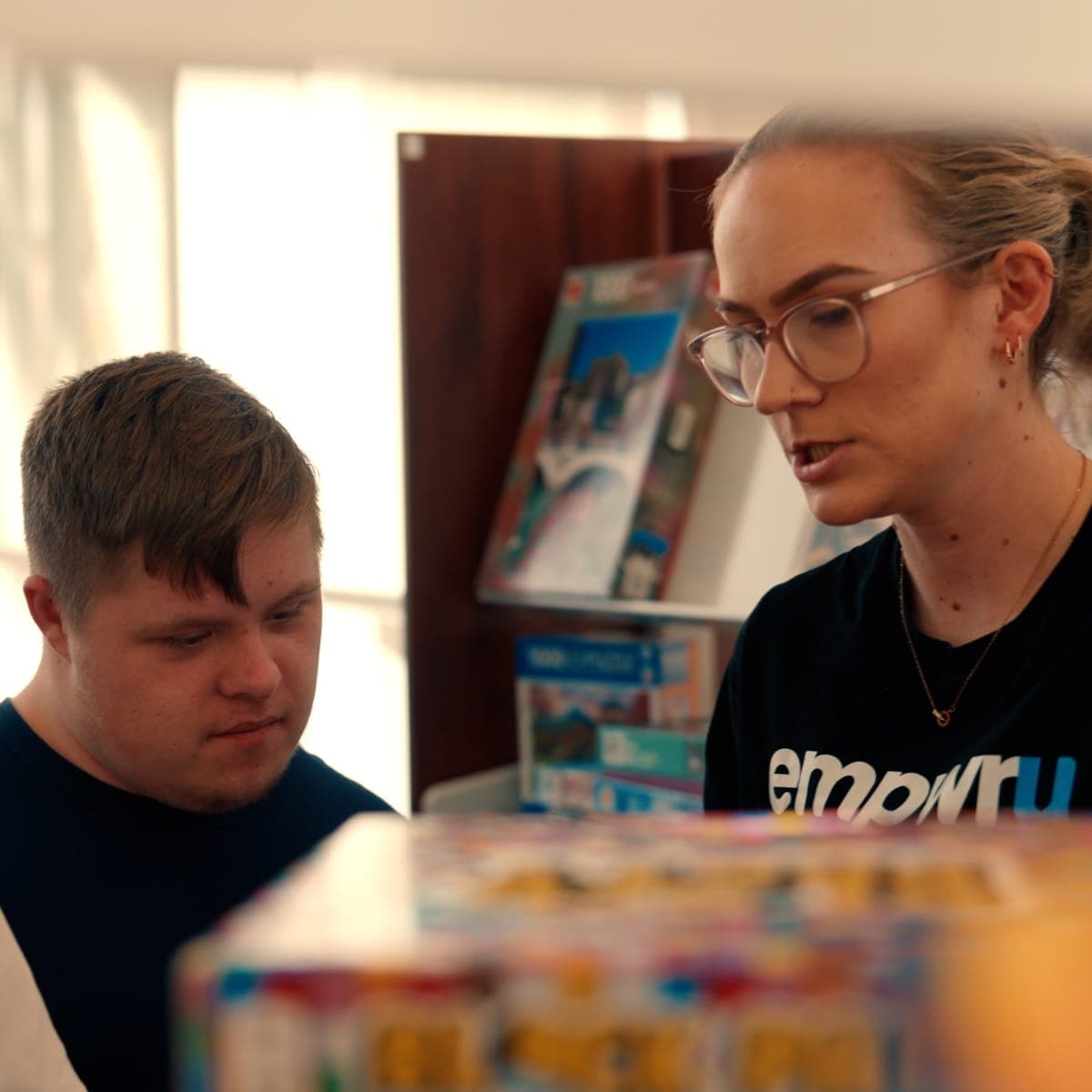 Looking through games and puzzles with an EmpwrU support worker